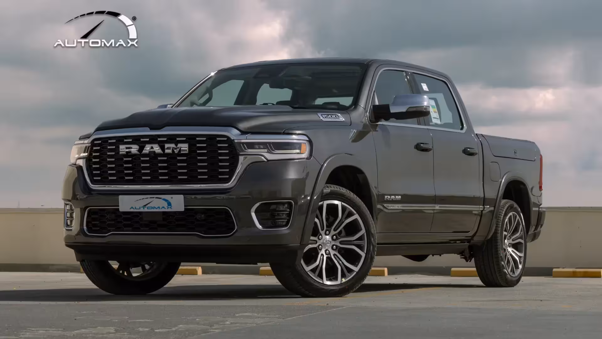 Front three-quarter view of a dark grey 2026 Ram 1500 Tungsten luxury pickup truck, parked on a concrete surface.