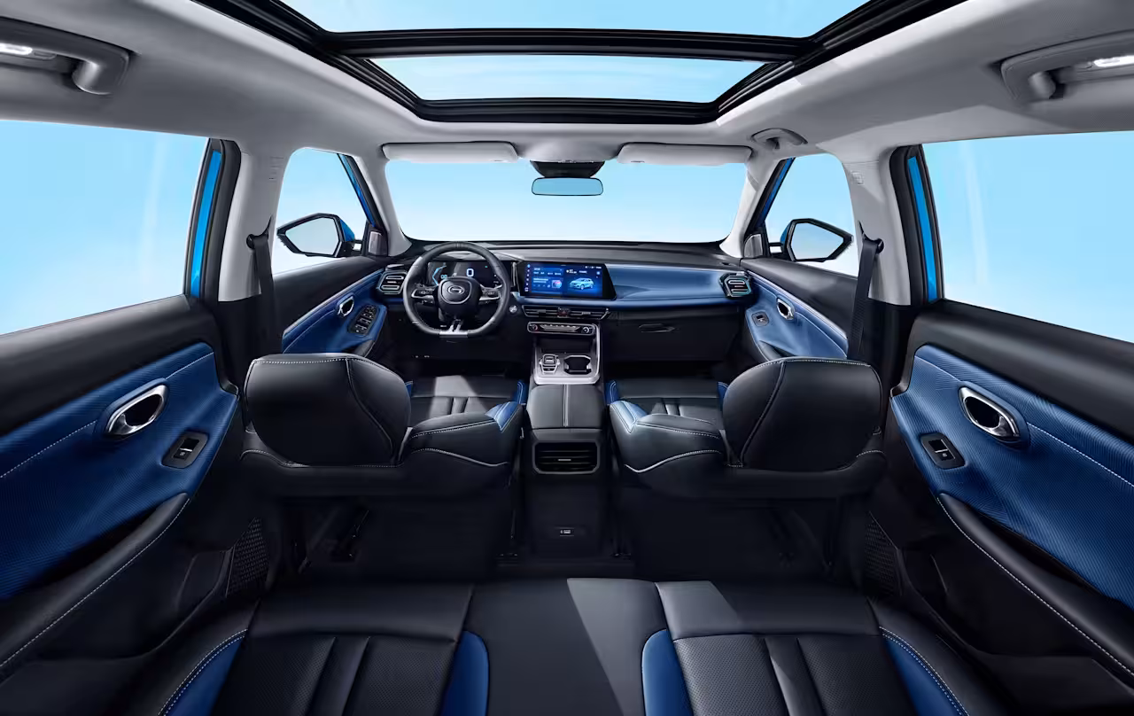 Wide-angle interior view of the 2026 GAC GS3 EMZOOM showcasing the dual-screen dashboard, blue-and-black two-tone interior, and panoramic sunroof.