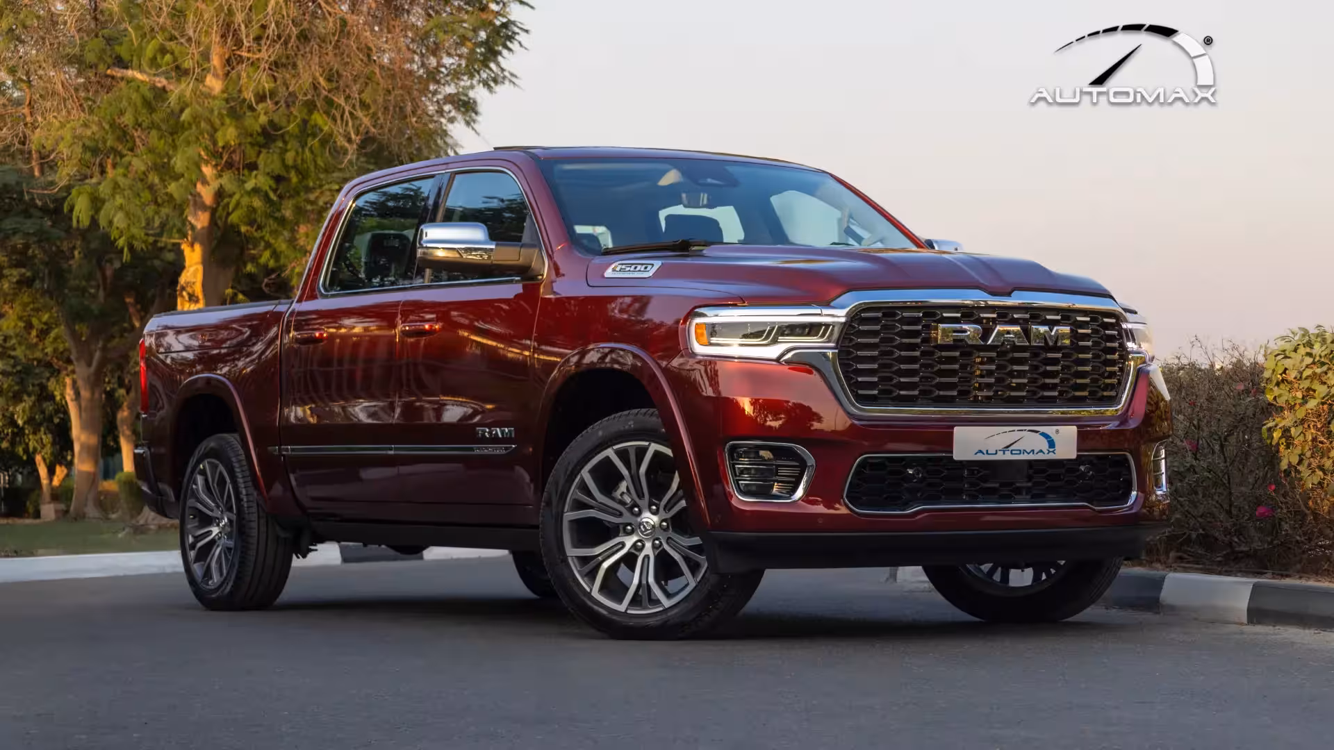 Front three-quarter view of a deep red 2026 Ram 1500 Tungsten luxury pickup truck, showcasing its bold grille and LED headlights.
