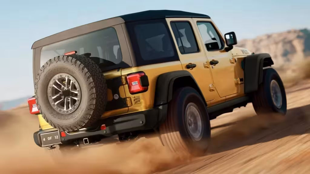 The 2026 Jeep Wrangler Unlimited Willys 392 in Goldilocks color, driving dynamically on a sandy desert dune, showcasing its powerful stance and large off-road tires. The '4 OF 12' license plate hints at its limited-edition status.