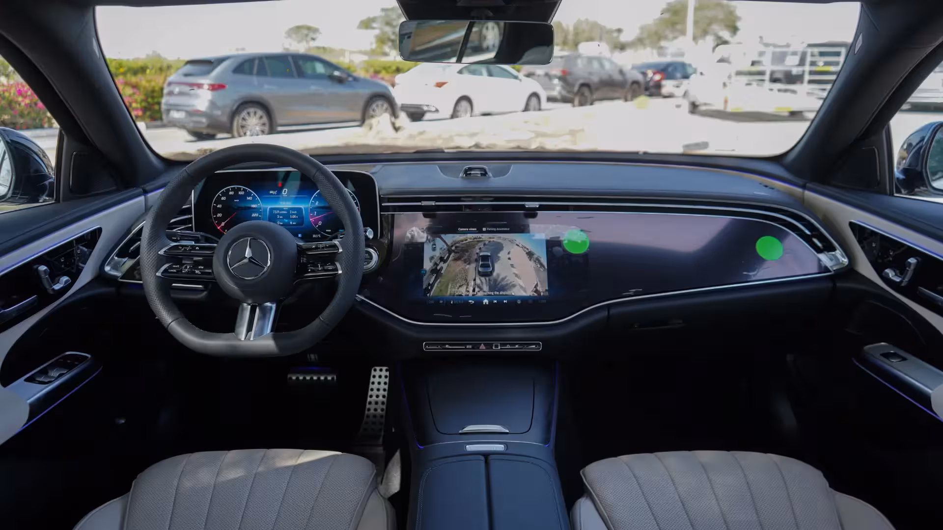 Interior view showing the front passenger and driver seats of the 2026 Mercedes-Benz E 200 AMG, upholstered in light-colored leather with a distinctive vertical ribbed pattern.
