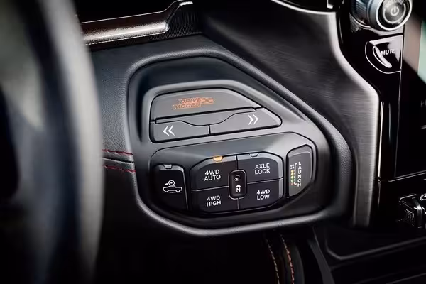 Close-up of the '6.2L SUPERCHARGED' badge prominently displayed on the functional hood scoop of the 2027 Ram 1500 SRT TRX, set against a desert backdrop.