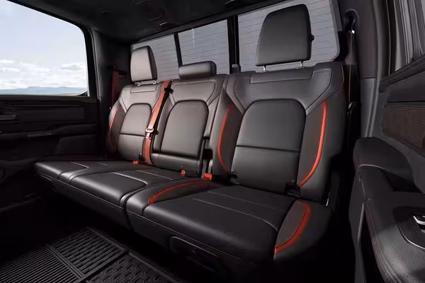 Interior view of the luxurious rear seats in the 2027 Ram TRX, featuring black leather with red piping, ample legroom, and headrests, highlighting comfort for all passengers.