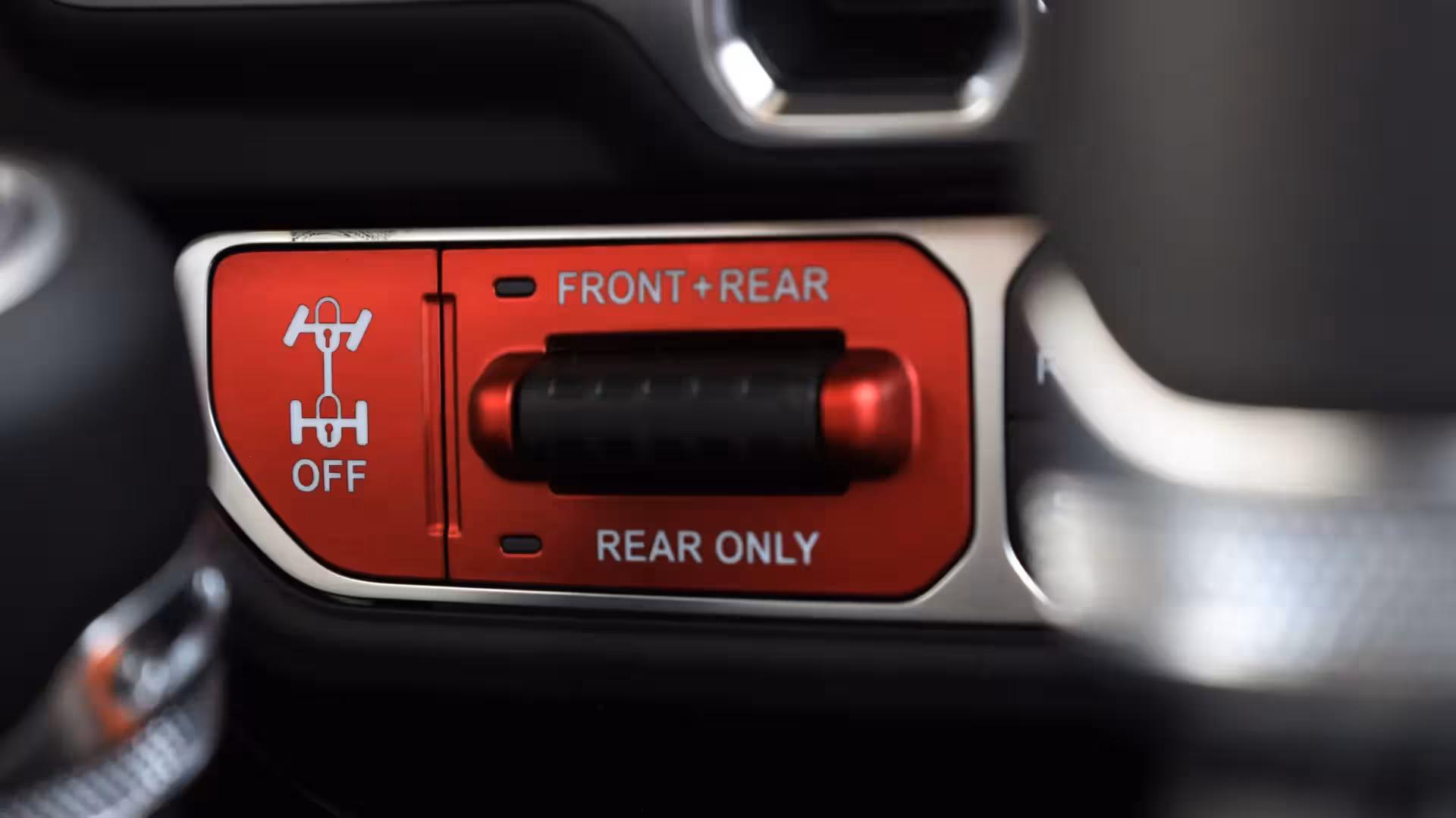 Close-up of the red and black 'TRAIL RATED 4x4' badge on a blue Jeep's exterior.