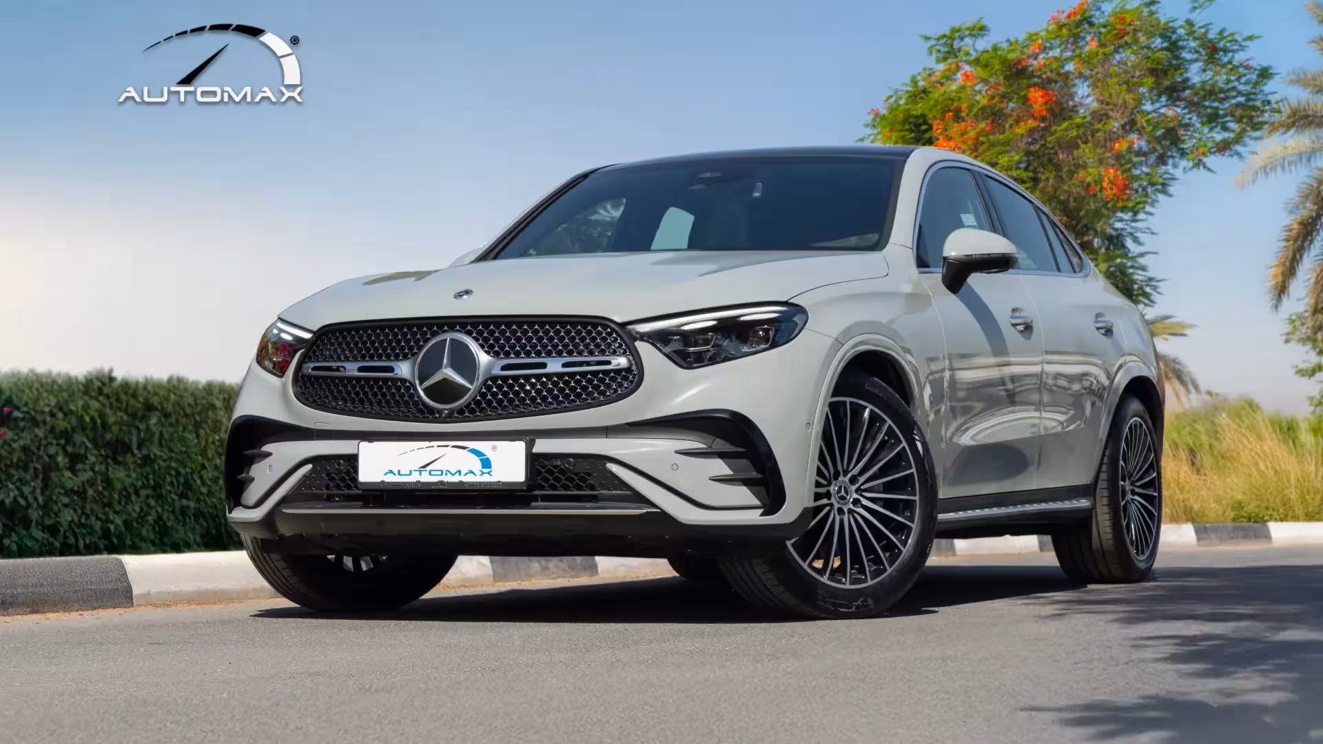 Direct front view of a white 2026 Mercedes-Benz GLC 200 Coupe, highlighting the large Mercedes-Benz star emblem on the 'diamond' pattern grille and the distinctive LED daytime running lights.