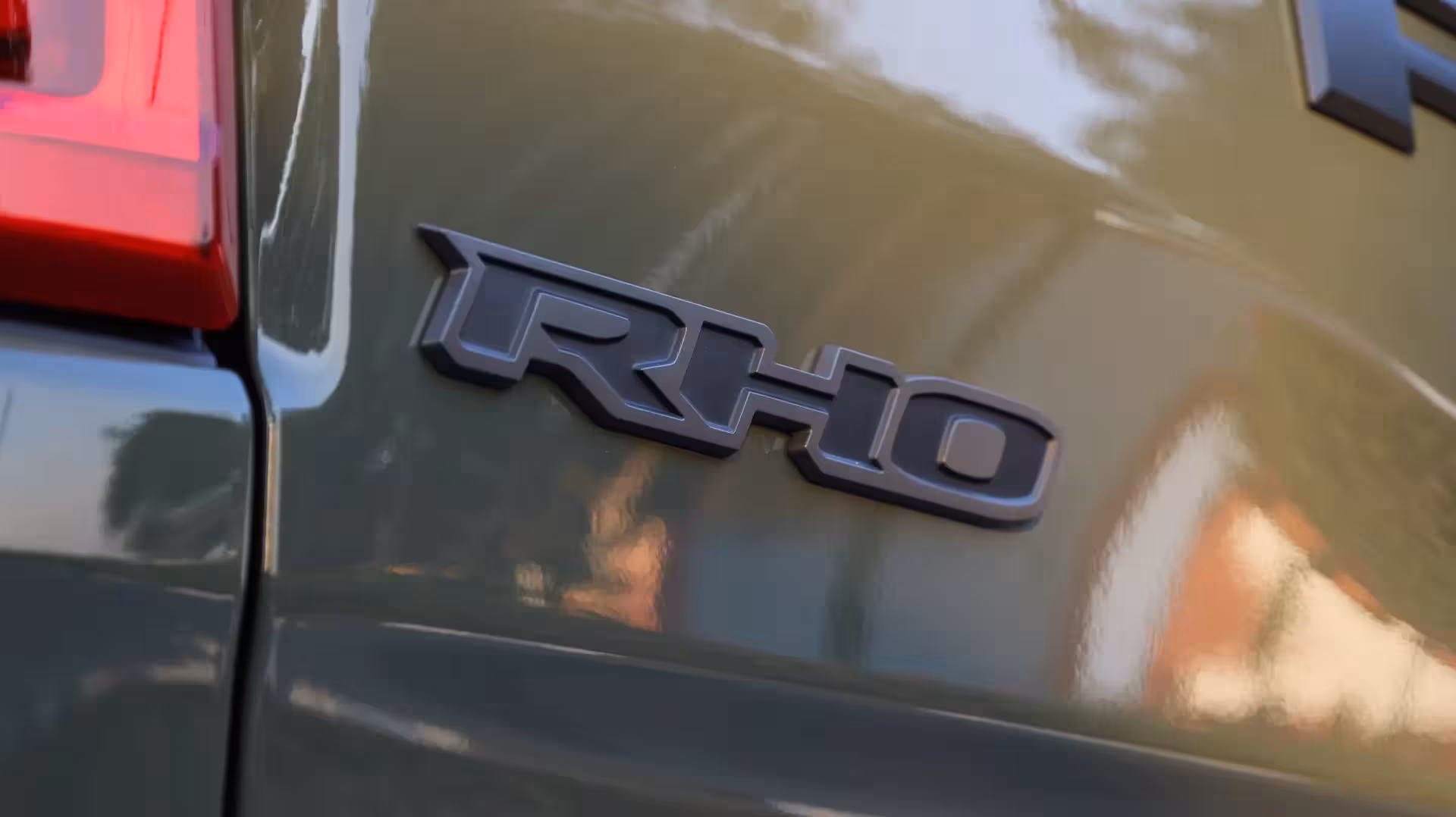 Close-up of the 'HURRICANE HIGH OUTPUT' badge with prominent red text on the matte black section of the Ram 1500 RHO's hood.